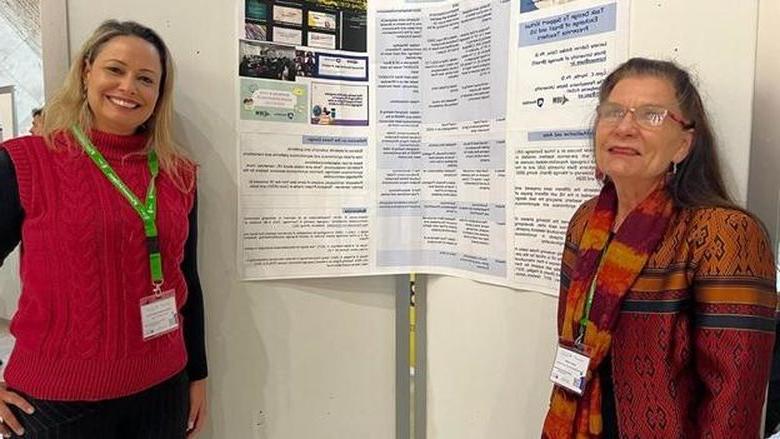 Two women giving a poster presentation